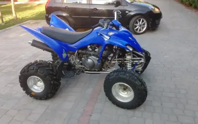 Niebieski Yamaha Raptor 350, quad z mocnym silnikiem, gotowy do jazdy. Ile ma koni? To pytanie dla fanów off-roadu!