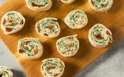 Roladki z tortilli ze szpinakiem i suszonymi pomidorami. Idealna szybka przekąska na imprezę lub do lunchboxa.