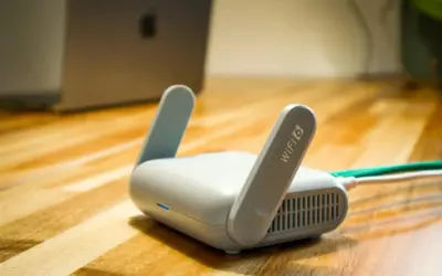 Router Wi-Fi 6 z antenkami, obok laptopa. Czy wiesz, upnp co to jest i jak ułatwia połączenia?