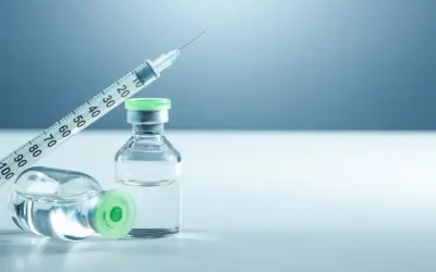 Strzykawka i dwie fiolki z zielonymi nakrętkami, jedna leżąca, druga stojąca. Mogą zawierać biofazolin.