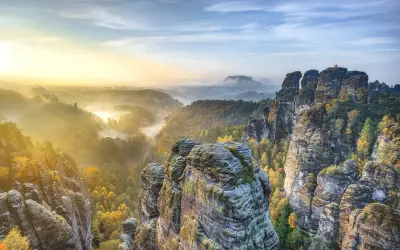 Morgendlicher Nebel über Felsformationen und Wäldern in der Sächsischen Schweiz. Ein perfekter Ort für einen Urlaub in Sachsen.
