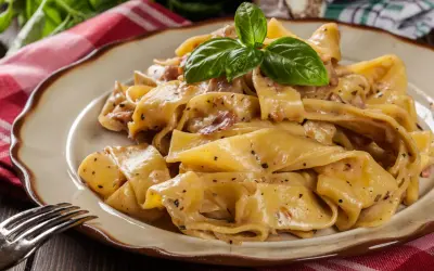 Cremige Pappardelle mit Speck und Kräutern, ein köstliches Pappardelle Rezept, garniert mit frischem Basilikum.