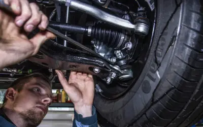 Mechanik pracuje pod samochodem. Prawdziwa historia klienta, który stracił gwarancję przez wymianę klocków poza ASO.