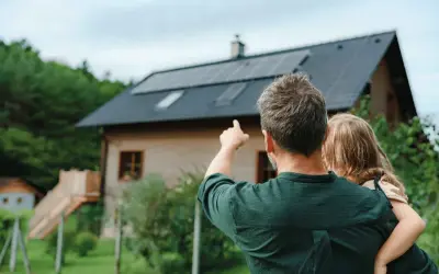 Padre e figlia guardano il tetto con pannelli solari. Un impianto fotovoltaico da 5 kW può produrre molta energia al giorno.