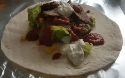 Domowy kebab z baraniną, sałatą, kukurydzą, sosem pomidorowym i jogurtowym na tortilli.