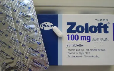 Opakowanie leku Zoloft 100 mg z sertraliną i pojedyncza tabletka.