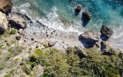 Vista aérea de la cala Barranco de Maro, con rocas, vegetación y el mar turquesa.