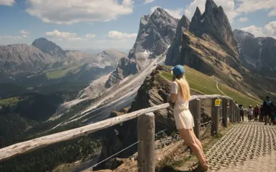 Dziewczyna podziwia spektakularne **dolomity co zobaczyć** – skaliste szczyty i zielone doliny.