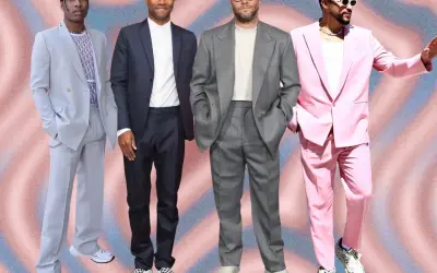 Four men in stylish suits with sneakers. A$AP Rocky in a light blue suit, Frank Ocean in a dark suit, Seth Rogen in a grey suit, and Bad Bunny in a pink suit.