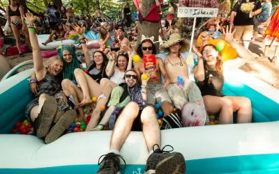 A group of friends enjoys a ball pit at the lil dub festival, laughing and posing for a photo.