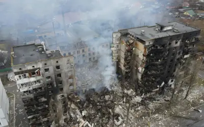 Zniszczone budynki mieszkalne, dym unoszący się nad gruzami, obraz tragedii, która rozpoczęła się, kiedy wybuchła wojna na Ukrainie.