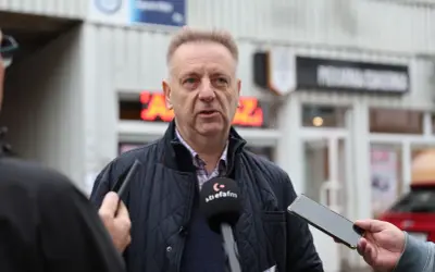 Mężczyzna udziela wywiadu, trzymając w ręku telefon. Może to być pomocne przy pisaniu odwołania do spółdzielni mieszkaniowej.