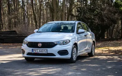 Biały Fiat Tipo na leśnej drodze. Wiele osób szuka fiat tipo opinie przed zakupem.