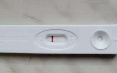 Blada kreska na teście ciążowym, widoczna przy literze "C", sugeruje wynik negatywny.