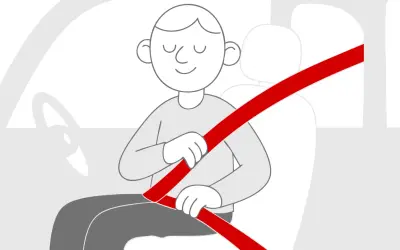 Uśmiechnięty kierowca zapina pasy, unikając mandatu za brak zapiętych pasów. Bezpieczeństwo przede wszystkim!
