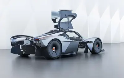 Aston Martin Valkyrie z otwartymi drzwiami, prezentujący futurystyczny design i aerodynamiczne linie.