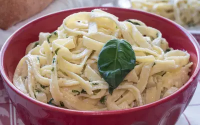 Tagliatelle condite con un delizioso sugo burro e salvia, guarnite con una foglia di basilico fresco.