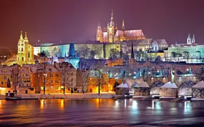 Wieczorny widok na Pragę zimą. Zamek na wzgórzu, most Karola i kolorowe kamienice tworzą magiczny krajobraz. Ciekawe ciekawostki o Czechach czekają na odkrycie!