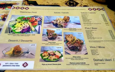 Menu z kuchnią bośniacką: wegetariański talerz, sałatki (w tym szopska), desery, piwo i wino.