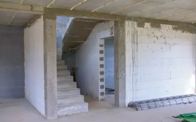 Wnętrze budowy z betonowymi schodami i otwartym przejściem. Jaki otwór pod drzwi 80 cm będzie idealny do tego pomieszczenia.