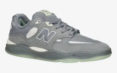 Szary but New Balance z logo "N" i widoczną tylną częścią buta.