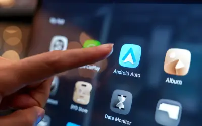 Palec dotyka ikony Android Auto na ekranie, pokazując, jak dodać aplikacje do Android Auto.