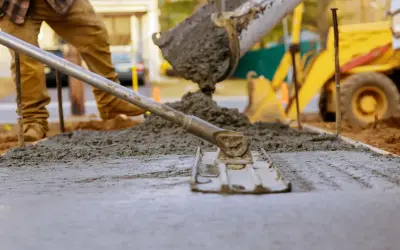 Wylewanie i wyrównywanie świeżego betonu na budowie.
