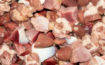 Kawałki surowego mięsa drobiowego, w tym serca i żołądki. Czy wątróbka to mięso? Tak, to podroby, które są częścią mięsa.