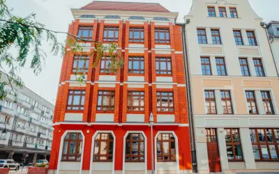 Jasna fasada i ceglany budynek przyciągają wzrok. Może tu mieści się filologia angielska we Wrocławiu?