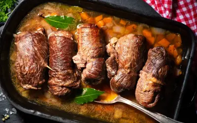 Pięć soczystych zrazów wołowych duszonych w aromatycznym sosie z warzywami. Sekret ich miękkości tkwi w długim, powolnym gotowaniu.