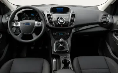 Interiörbild på en begagnad Ford Kuga. Ratt, instrumentpanel med skärm och växelspak syns tydligt. En bra bil för ett ford kuga begagnad test.