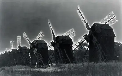 Mulini a vento in un campo, con un effetto di solarizzazione man ray che illumina le pale.