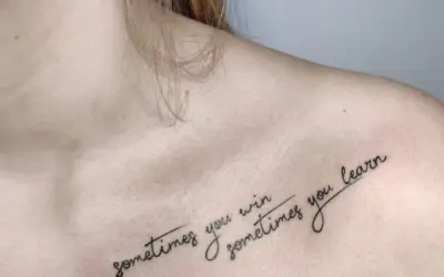 Delikatny tatuaż na dekolcie z napisem "sometimes you win, sometimes you learn".