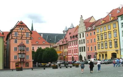 Kolorowe kamienice w **cheb** tworzą malowniczy rynek. Ludzie spacerują po brukowanym placu, podziwiając architekturę.