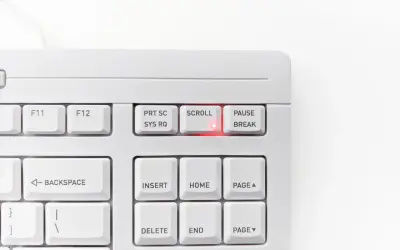 Biała klawiatura z podświetloną na czerwono diodą przy klawiszu SCROLL LOCK. Klawisz PAUSE/BREAK obok.