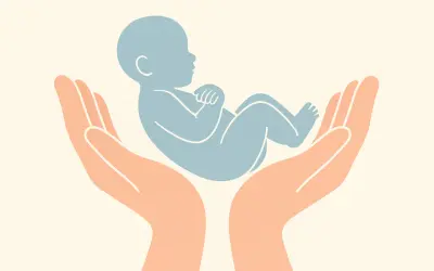 Dwie dłonie podtrzymują niebieskie dziecko. Delikatny dotyk, jak podczas masażu shantala, otacza maluszka troską i bezpieczeństwem.