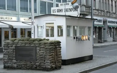 Checkpoint Charlie, dawne miejsce kontroli granicznej, z workami z piaskiem i tablicą pamiątkową.