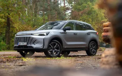 Srebrny SUV na leśnej drodze. Wiele osób szuka baic 7 opinii przed zakupem.