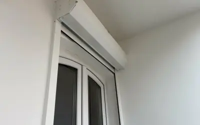 Un imposte blanc est installé au-dessus d'une porte-fenêtre blanche.