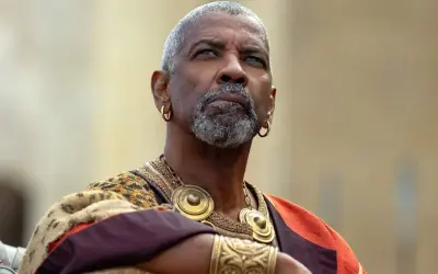 Denzel Washington med grått skägg och guldörhängen, klädd i en historisk dräkt. En ikonisk skådespelare känd från många denzel washington movies.