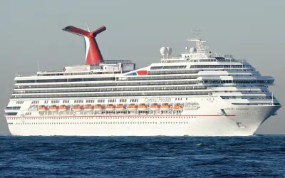 Das Kreuzfahrtschiff Carnival Freedom gleitet über das Meer. Die roten Rettungsboote sind bereit für den Carnival-Spaß.