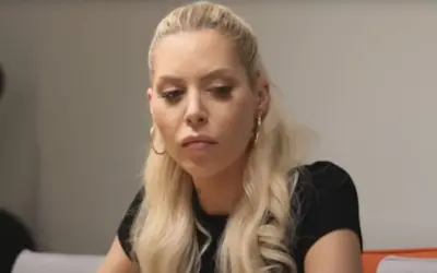 Julia von Stein z blond włosami i kolczykami w kształcie kółek, zamyślona.
