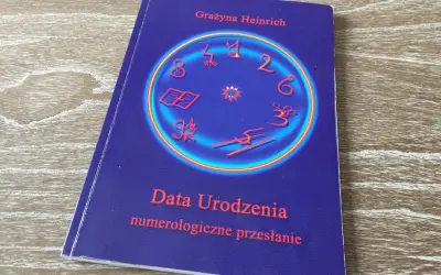 Okładka książki "Data Urodzenia numerologiczne przesłanie" Grażyny Heinrich. Centralny element to okrąg z cyframi i symbolami, sugerujący analizę liczby numerologicznej.