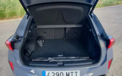 Bagagliaio aperto della Cupra Terramar, con ombrello e kit di emergenza. Le dimensioni sono adatte per un viaggio.