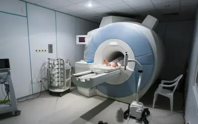 Pacjent leży na stole do rezonansu magnetycznego, gotowy na badanie MR.
