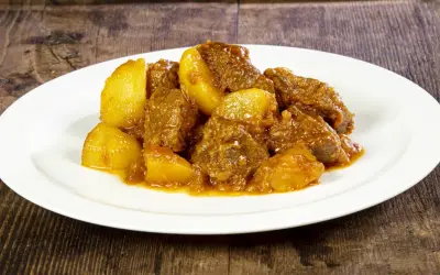 Spezzatino con patate, la ricetta della nonna che scalda il cuore. Morbidi pezzi di carne e patate dorate in un sugo saporito.