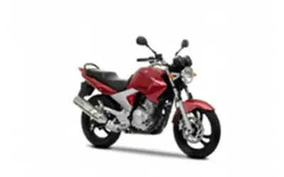 Czerwony motocykl Yamaha YBR 250 z czarnym siedzeniem i srebrnym wydechem, gotowy do jazdy po mieście.