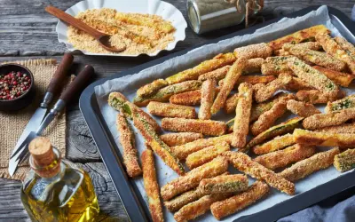 Fettine dorate di chips di zucchine pronte per essere gustate, su una teglia da forno.
