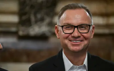 Uśmiechnięty mężczyzna w okularach, w garniturze. Czyżby planował już emeryturę prezydencką?