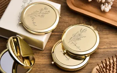 Un miroir de poche personnalisé, orné de délicates fleurs et d'un prénom, prêt à illuminer le quotidien.